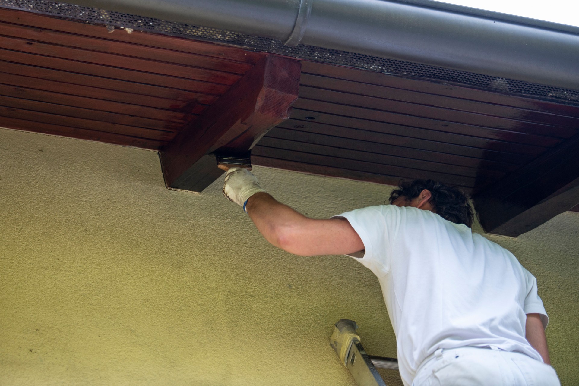 Hombre adulto pintando madera en la casa