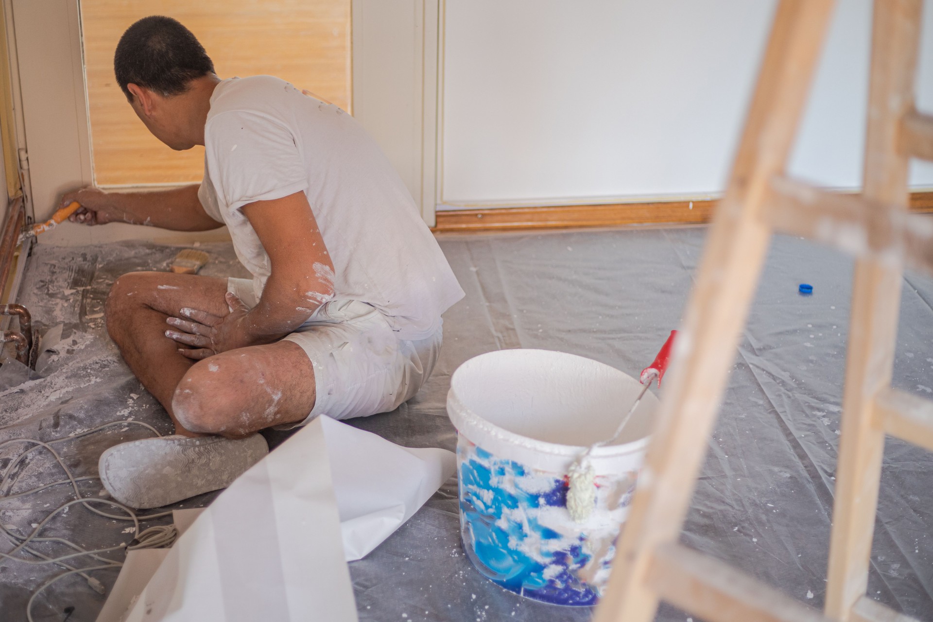 Renovation, a man paints a wall with a hand brush